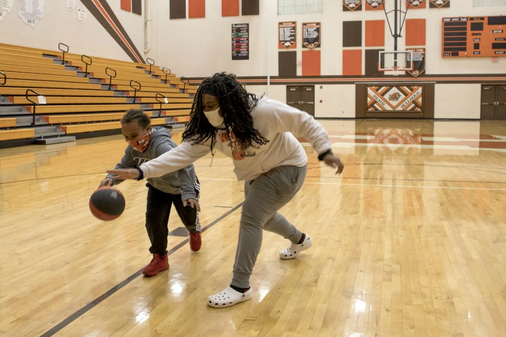 Third Place, Sports Picture Story - Jessica Phelps / Newark Advocate, “Coaching Creates Deep Roots For Croom Family”Taya Croom plays a tough game of 1 on 1 with her nephew Kam in the Heath High School gum after cheering for her niece, Taliyah at her varsity basketball game on December 15, 2020. 